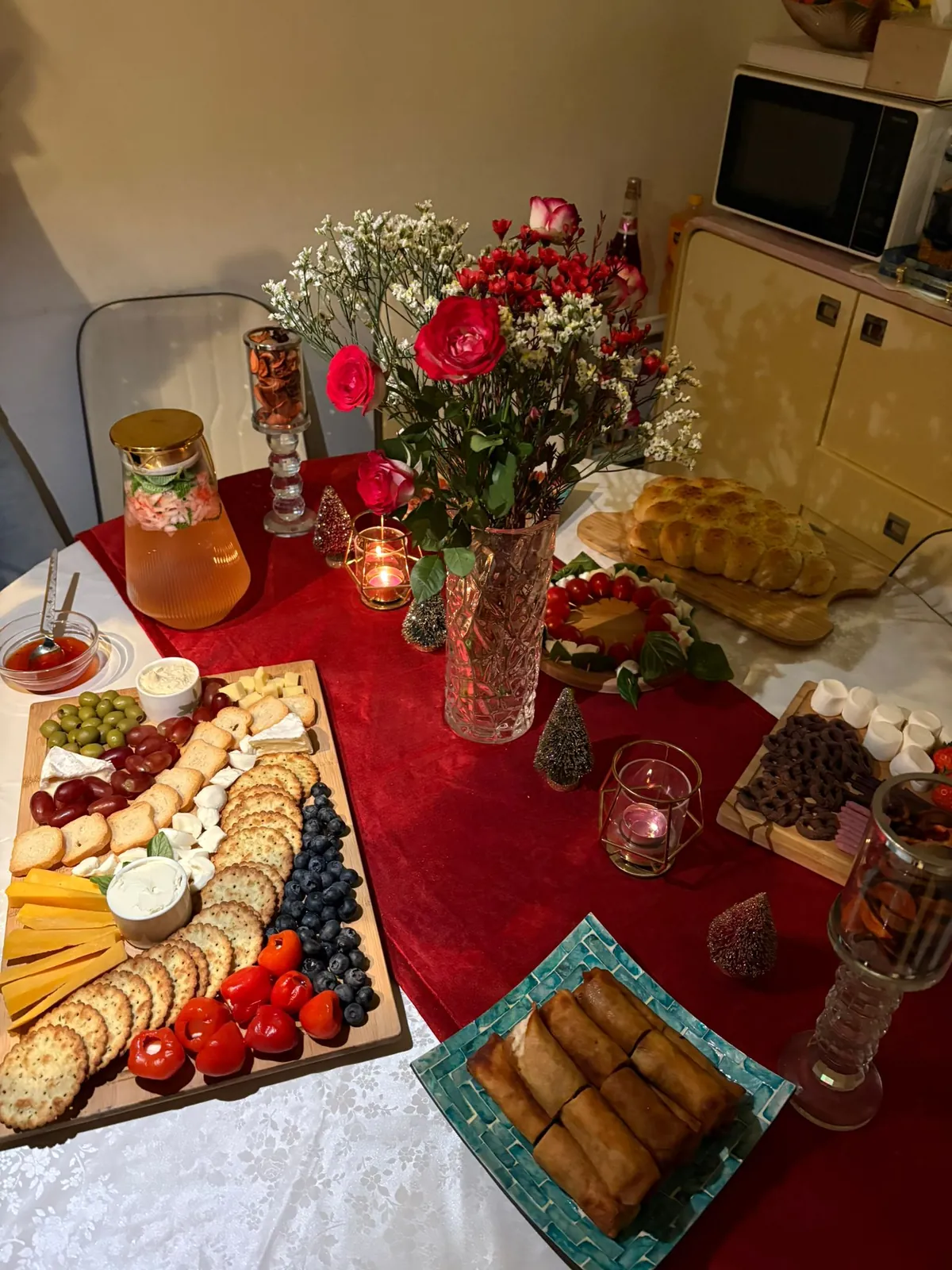 Christmas party table styled by Ghanjani Jain with a red runner, roses and a festive spread