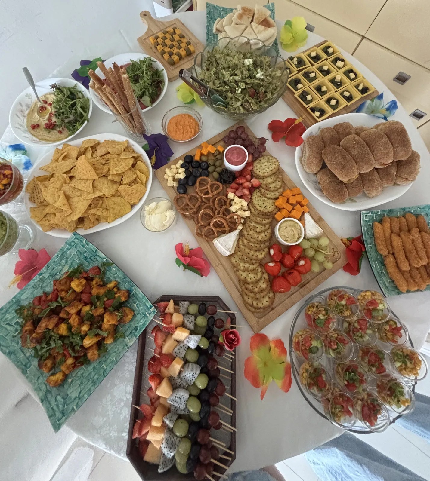 Tropical party food spread styled and cooked by Ghanjani Jain, with hibiscus flowers and teal platters